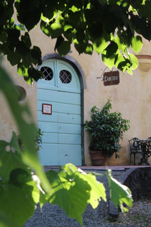 a blue door in the side of a building with a bench at Azienda Agricola Fabbrica Di San Martino in Lucca