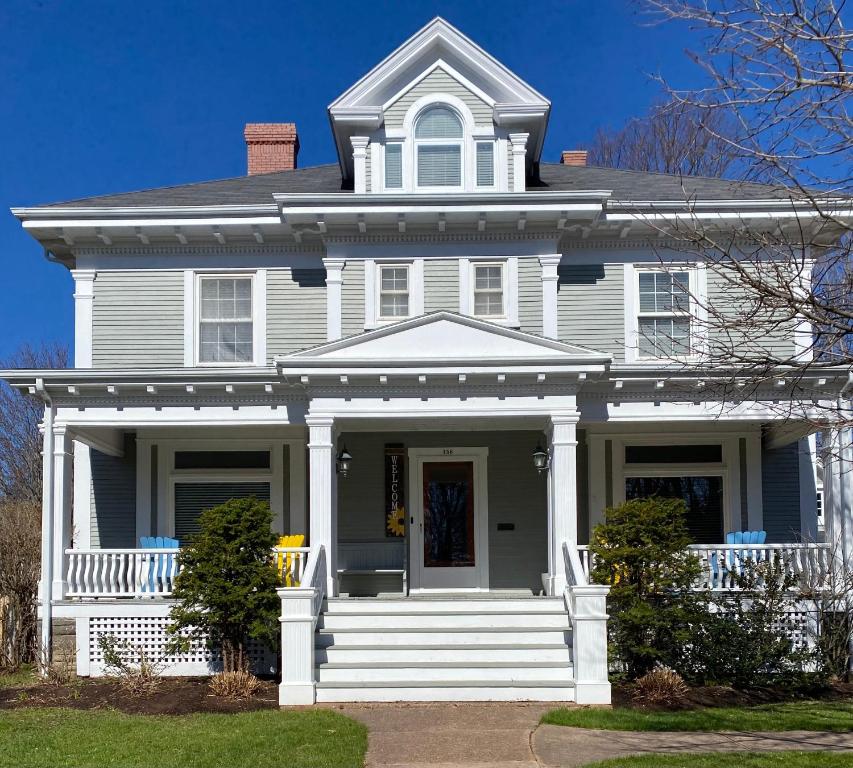 a white house with a white porch at The Boardwalk Inn in Summerside