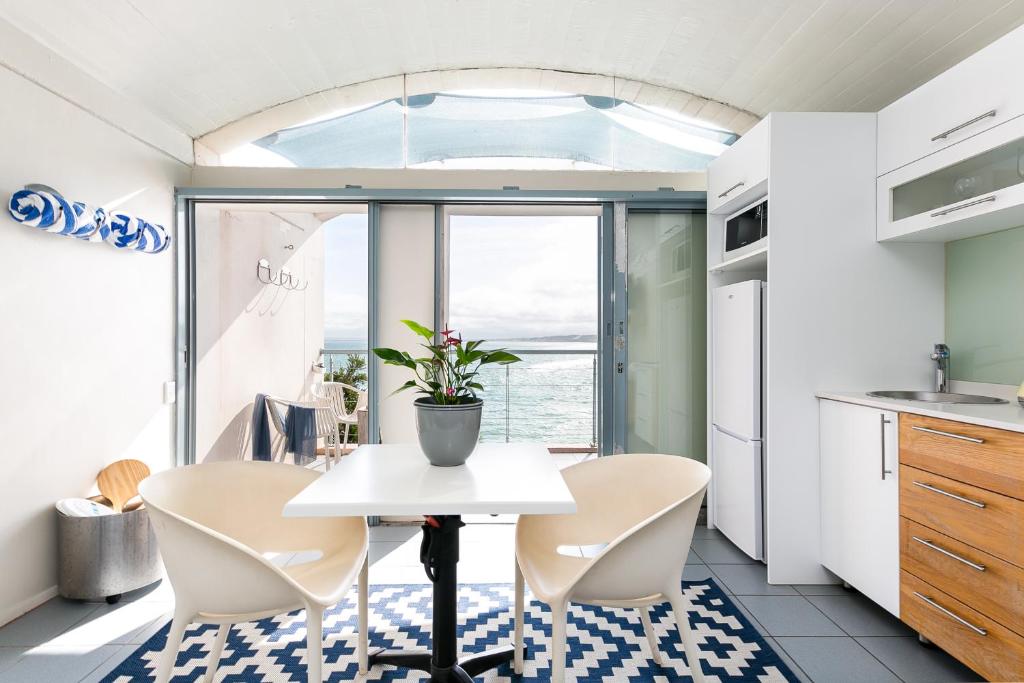 a kitchen with a table and chairs and a window at Speelhuis Studios in Langebaan