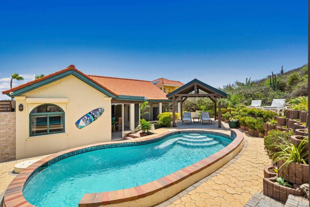 a swimming pool in front of a house at Caya Mesa Vista 8 Tierra del Sol in Noord
