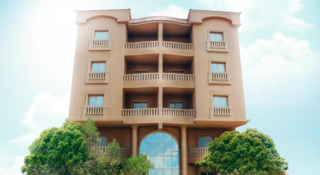 a tall building with a tree in front of it at Prime Residence New Cairo in Cairo