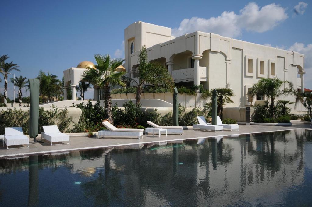 um resort com uma piscina em frente a um edifício em Visir Resort Spa em Mazara del Vallo