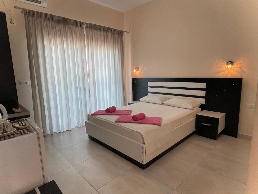 a bedroom with a large bed with pink towels on it at Marku Palace in Ksamil