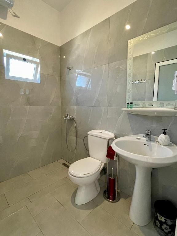 a bathroom with a toilet and a sink at Marku Palace in Ksamil
