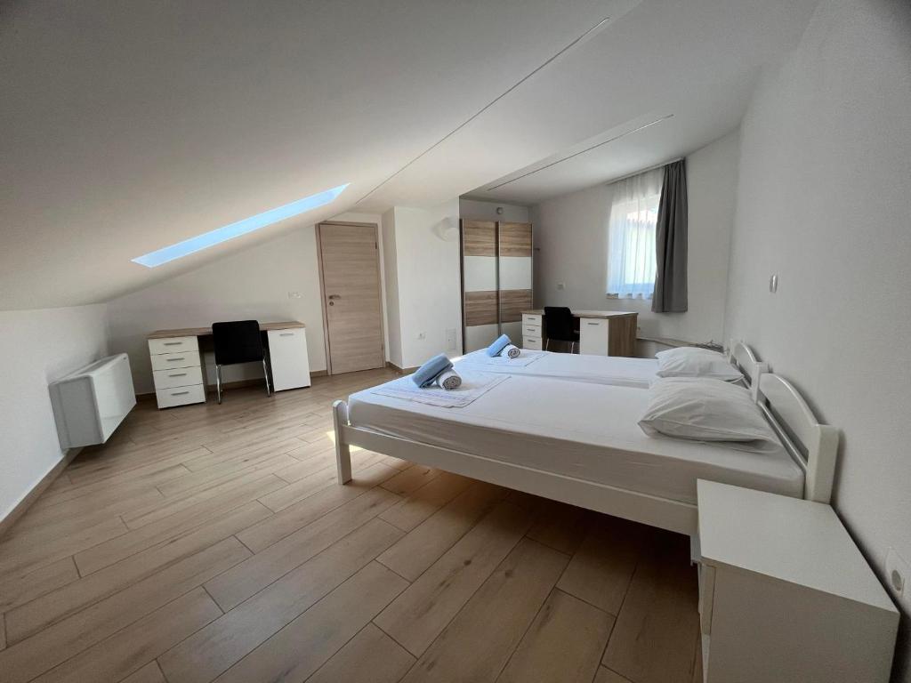 a large white bedroom with a bed and wooden floors at Villa Ivanka in Koper
