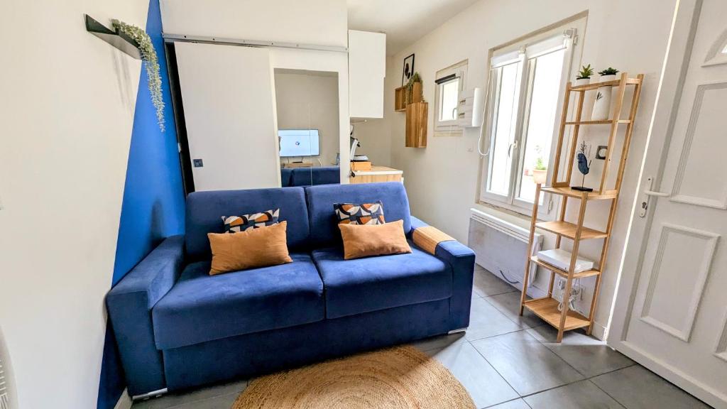 - un canapé bleu avec deux oreillers dans le salon dans l'établissement Studio *Sérénité*, à Villejuif