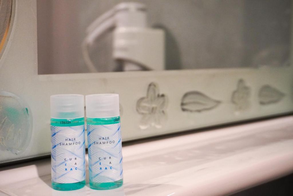 two tubes of toothpaste sitting on a sink in front of a mirror at Marku Palace in Ksamil