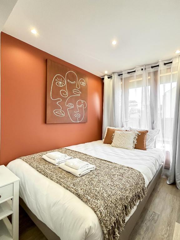 une chambre avec un grand lit avec un mur orange dans l'établissement Hoche Apartment - PSG, à Le Pré-Saint-Gervais