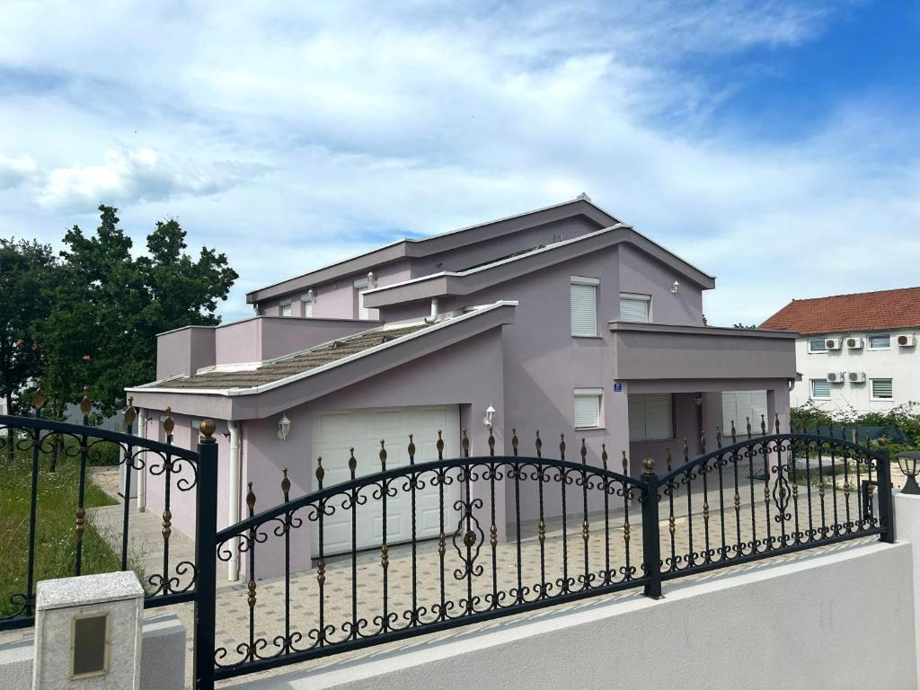 a pink house behind a black fence at Beautiful Villa near Medjugorje in Međugorje