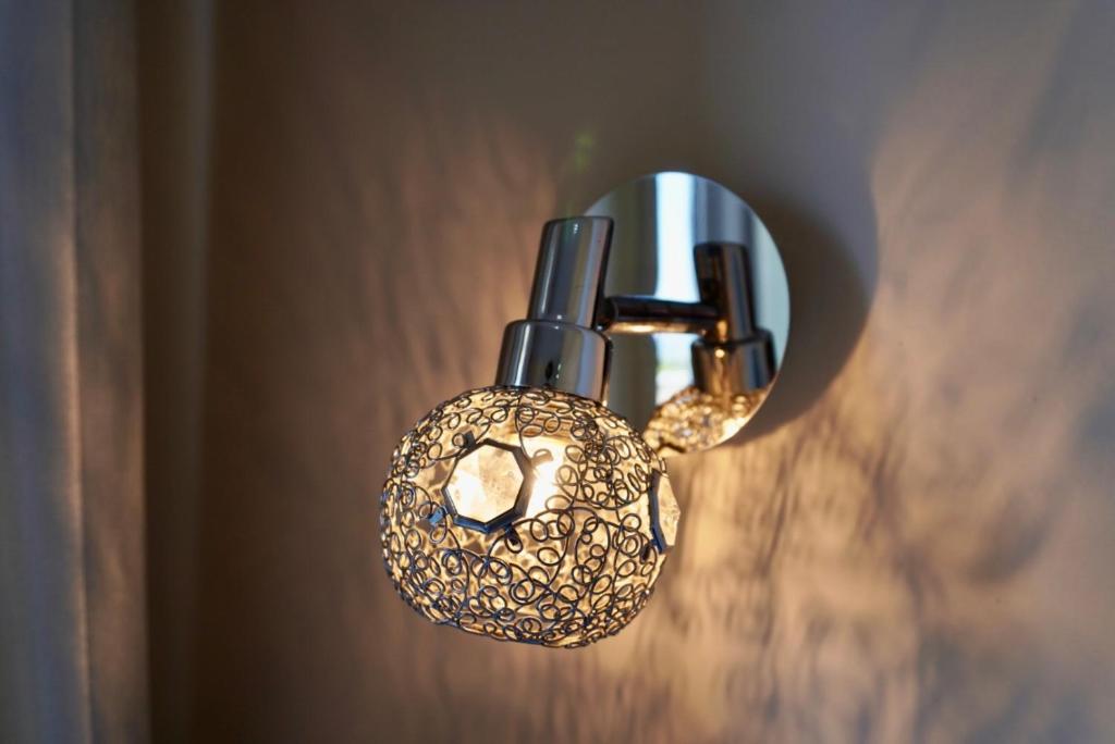 a light fixture on a wall with a doughnut on it at Marku Palace in Ksamil