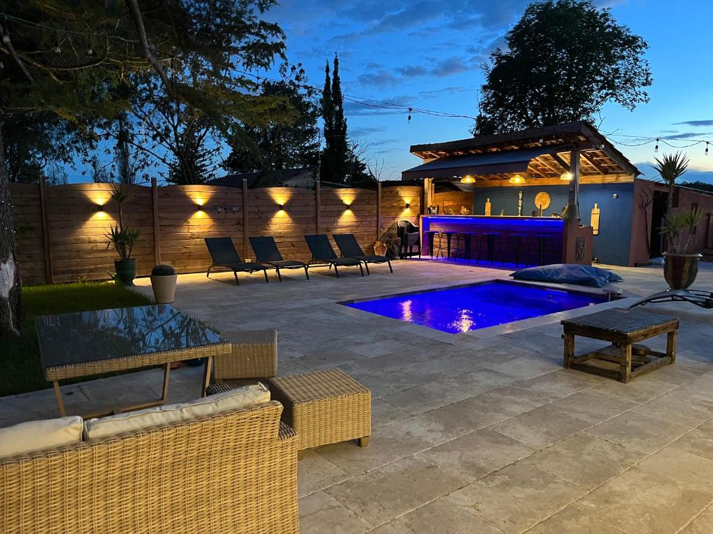 a patio with a pool and chairs and a fence at Le mazet de fabrègues in Fabrègues