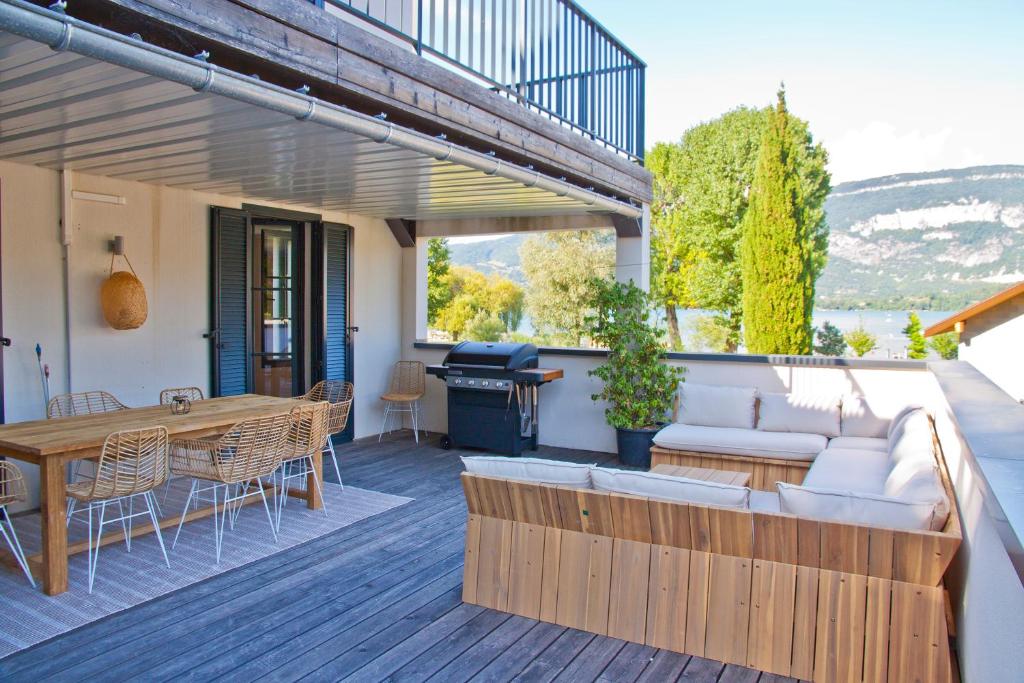 une terrasse avec un canapé, une table et un grill dans l'établissement Superbe appartement sur la plage, à Conjux