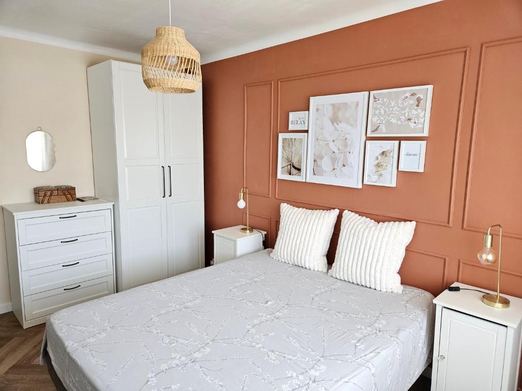 une chambre avec un grand lit aux murs orange dans l'établissement Appartement rénové dernier étage en ville et au calme, à Toulon