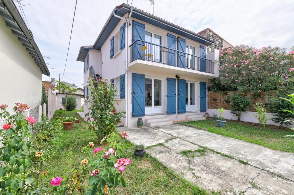 une maison avec des portes bleues et une cour dans l'établissement L’Ostalet ~ Parking ~ Jardin ~ Rangueil, à Toulouse
