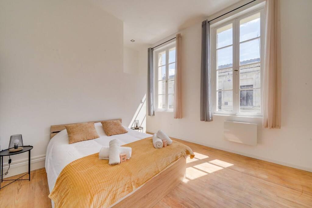 une chambre avec un lit avec deux animaux en peluche dessus dans l'établissement Maison rénovée en centre ville, à Libourne