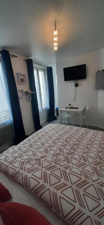 une chambre avec un grand lit dans une pièce dans l'établissement Studio place Roger Levanneur, à Montmorency