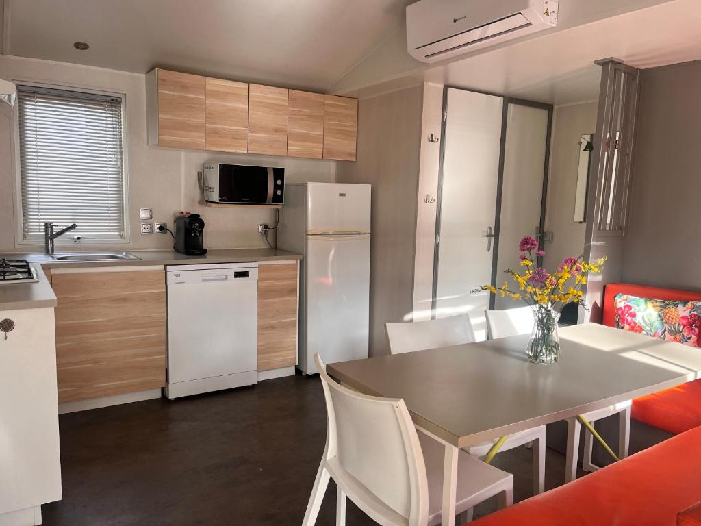 une cuisine et une salle à manger avec une table et des chaises dans l'établissement Camping la sainte baume, à Nans-les-Pins