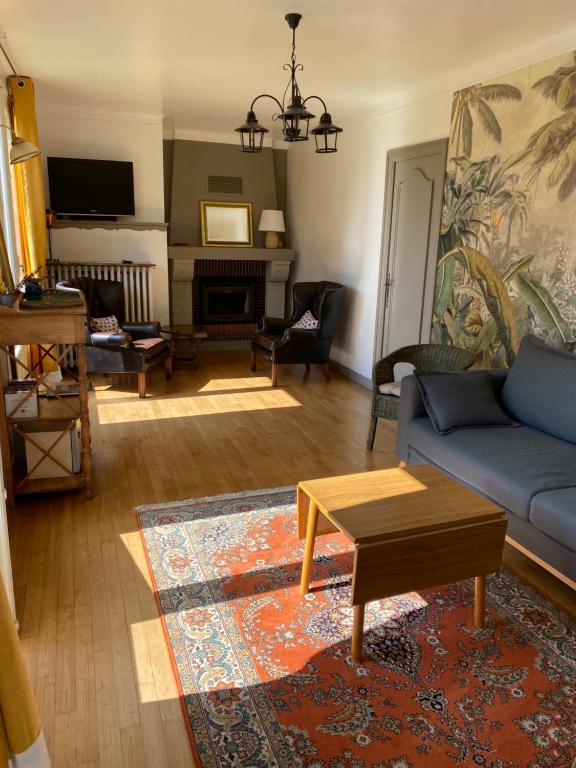 un salon avec un canapé bleu et une table dans l'établissement Maison de ville avec jardin, à Malestroit