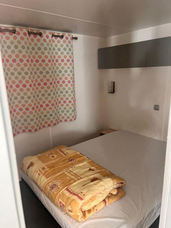une petite chambre avec un lit et un rideau dans l'établissement Camping la sainte baume, à Nans-les-Pins 17 autres photos