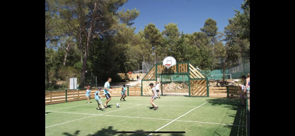 - un groupe d'enfants jouant au football sur un terrain dans l'établissement Camping la sainte baume, à Nans-les-Pins