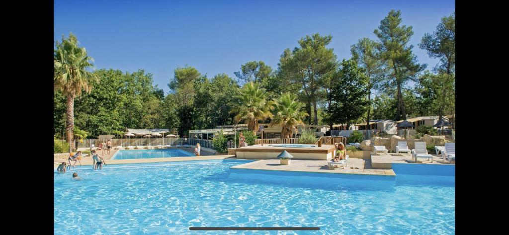 - une piscine dans un complexe avec des personnes dans l'établissement Camping la sainte baume, à Nans-les-Pins