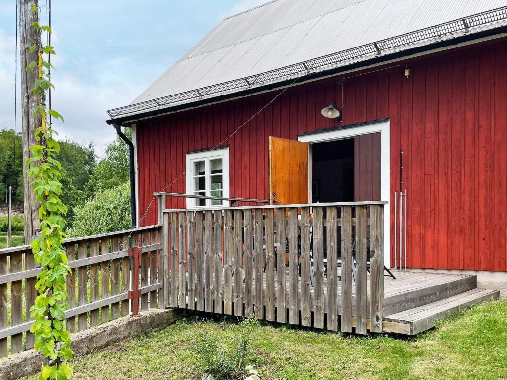 a red house with a wooden fence in front of it at 4 star holiday home in SVÄNGSTA in Svängsta