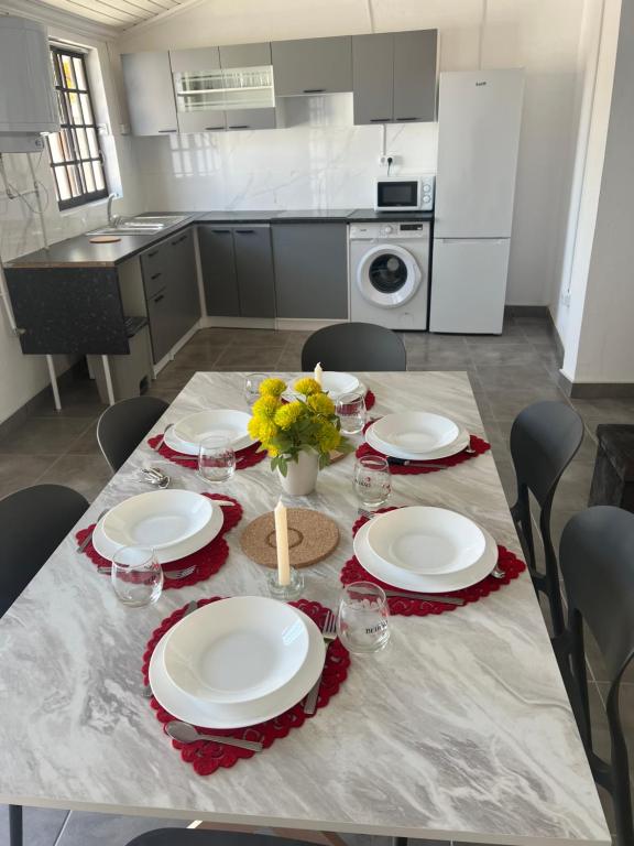a table with plates and flowers on it in a kitchen at Casa da alegria in Vieira de Leiria