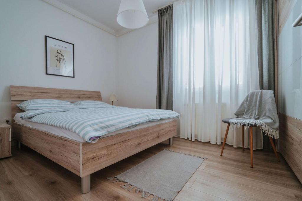 a bedroom with a wooden bed and a window at Apartman III u centru Kutine in Kutina