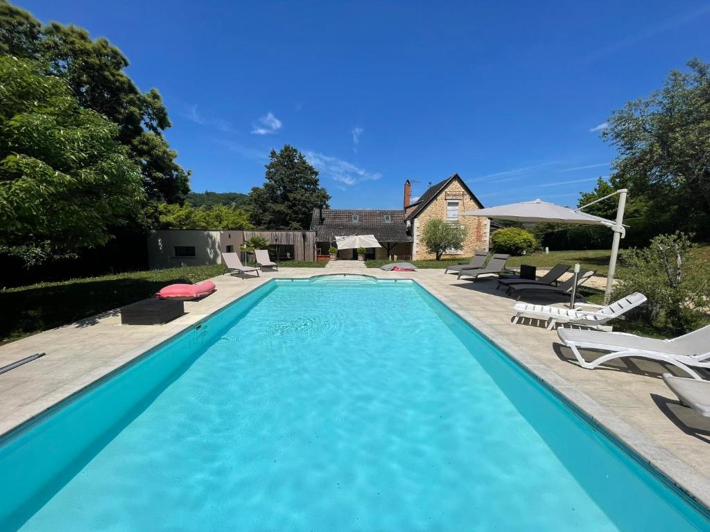 une grande piscine avec des chaises et une maison dans l'établissement Propriété*Piscine*Sarlat, à Sarlat-la-Canéda