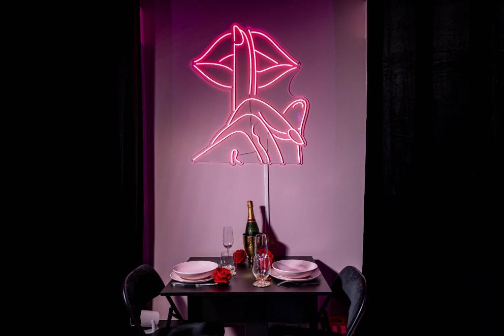 ヴィルパントにあるPinky Roomの紫色の壁にネオンサインがついたテーブル