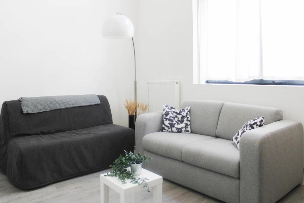 un salon avec un canapé et une chaise dans l'établissement Duplex adjoining the Eiffel hall La Communale, à Saint-Ouen