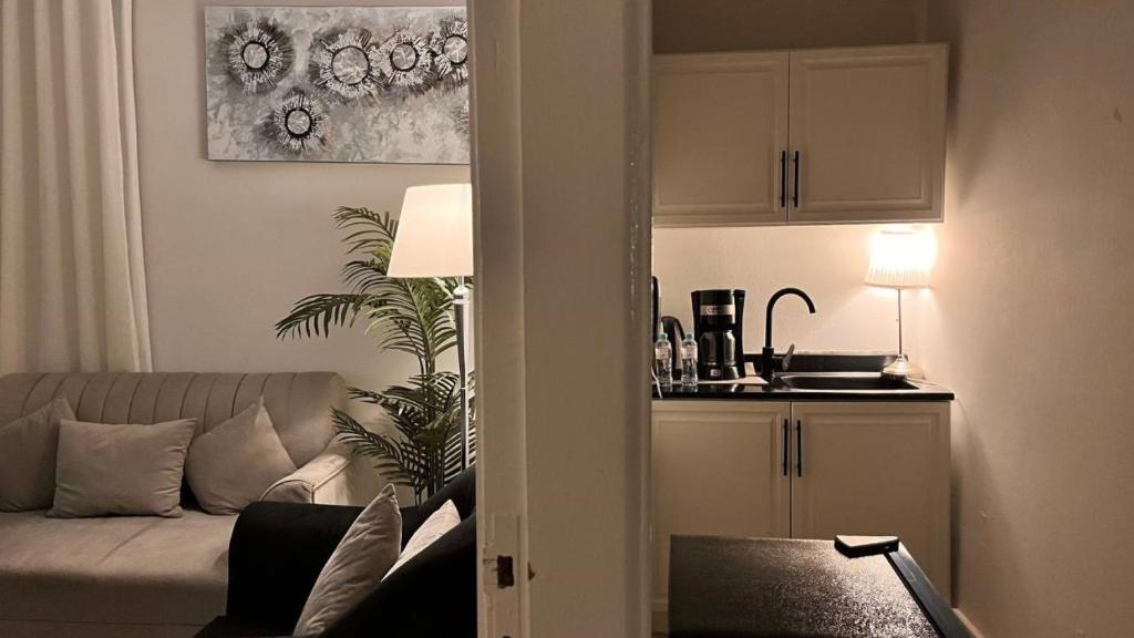 un salon avec un canapé et une cuisine dans l'établissement أستديو Studio Hiten- Boulevard, à Riyad