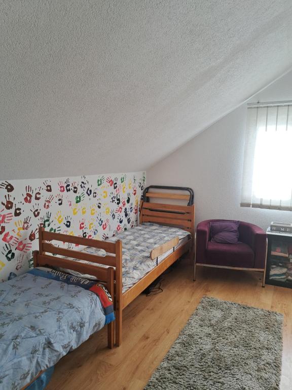a bedroom with two bunk beds and a chair at Apartmani grahovo in Nikšić