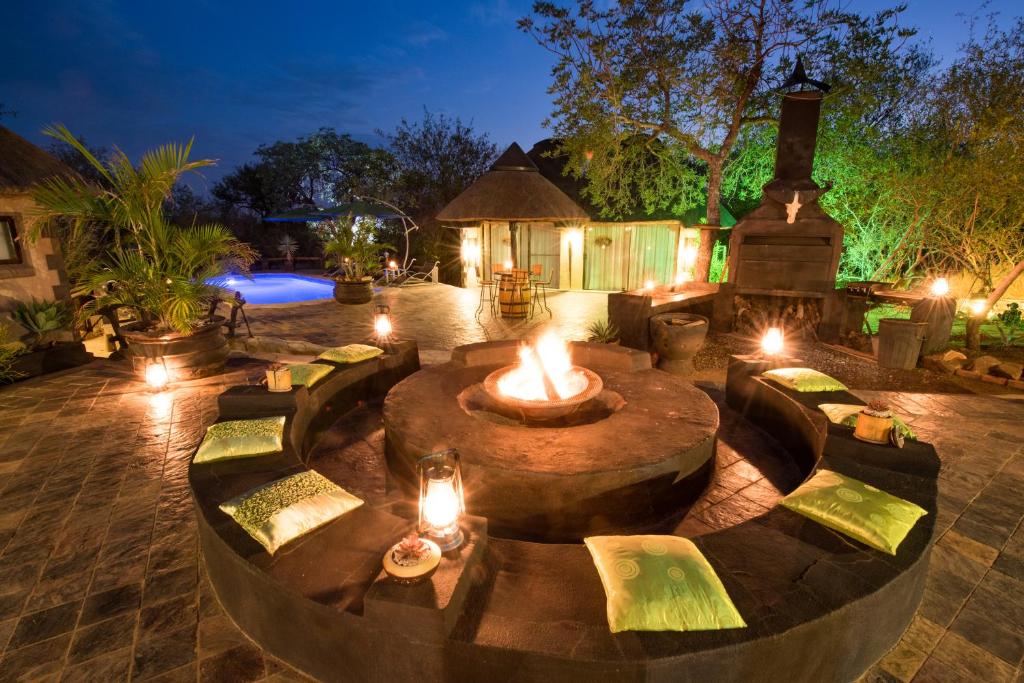 a backyard with a fire pit with lights and a house at African Rock Lodge in Hoedspruit