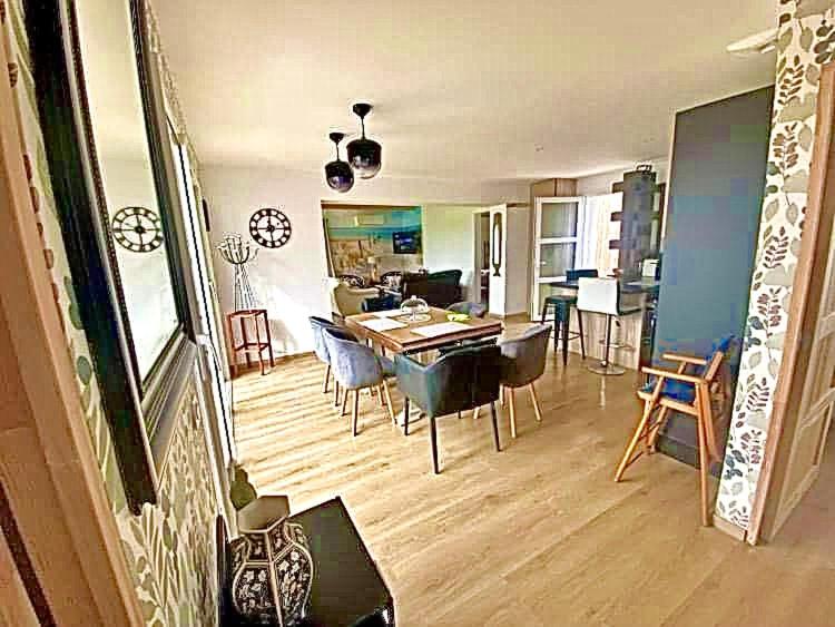 une salle à manger et un salon avec une table et des chaises dans l'établissement La villa de Porsguen et des crustacés - Plouescat, à Plouescat