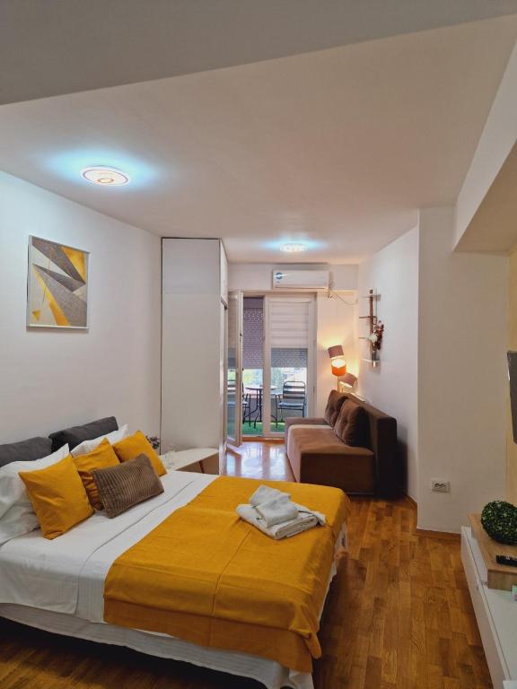 a bedroom with a large bed and a couch at Kamche apartment in Skopje