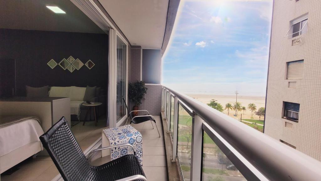 a balcony with two chairs and a view of the ocean at Book Santos - Unlimited 618 - Veja e escute o Mar in Santos