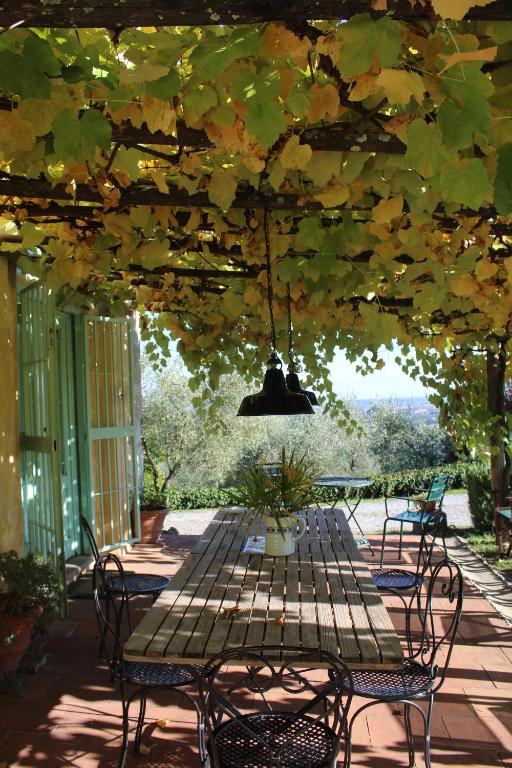 a patio with a table and chairs under a pergola at Azienda Agricola Fabbrica Di San Martino in Lucca