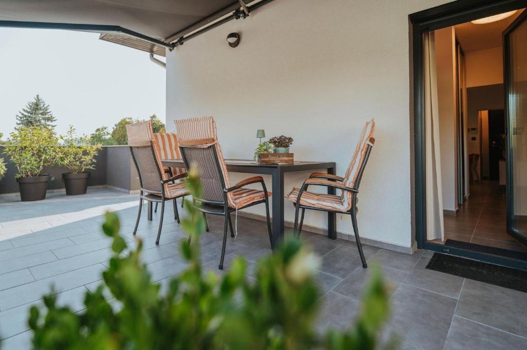 a group of chairs around a table on a patio at Apartman IV u centru Kutine. in Kutina