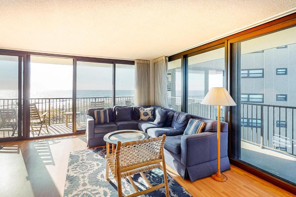 a living room with a blue couch and a balcony at Sea Colony - 610 Dover House Rd. in Bethany Beach