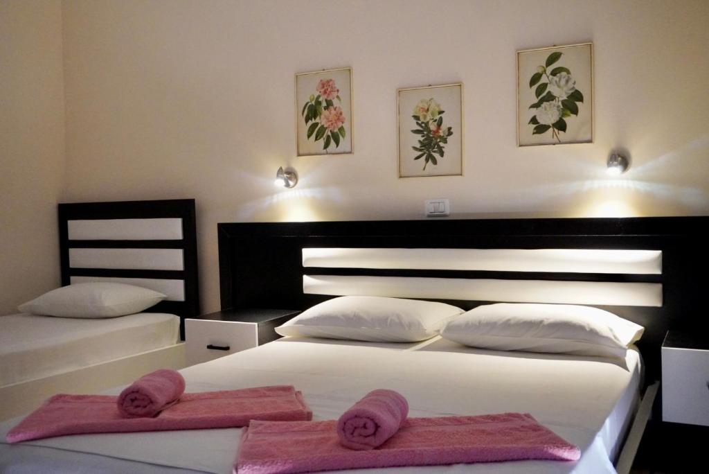 a bedroom with two beds with pink towels on them at Marku Palace in Ksamil