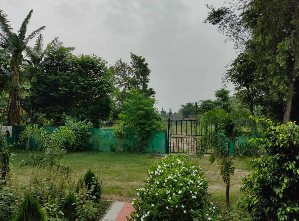 a garden with a gate in the middle of a yard at Sudarshan Resort in Haraincha