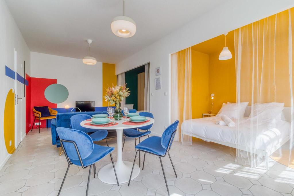 une pièce avec une table, des chaises et un lit dans l'établissement L'Espace Pop - Confort - Calme - Atypique, à Douai