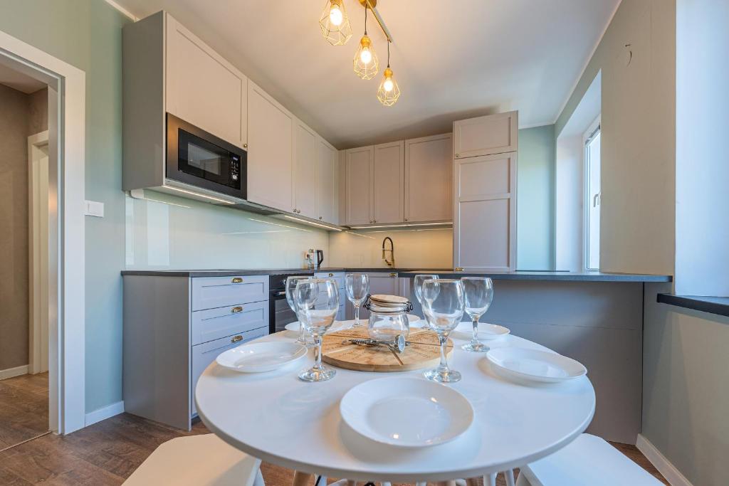 Una cocina con una mesa con copas de vino encima. en Grand Solen Apartment, en Gdansk