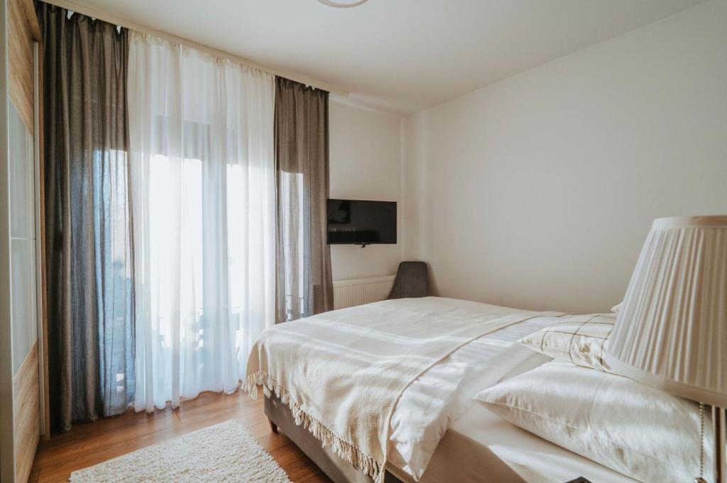 a bedroom with a bed and a large window at Apartman VI u centru Kutine in Kutina