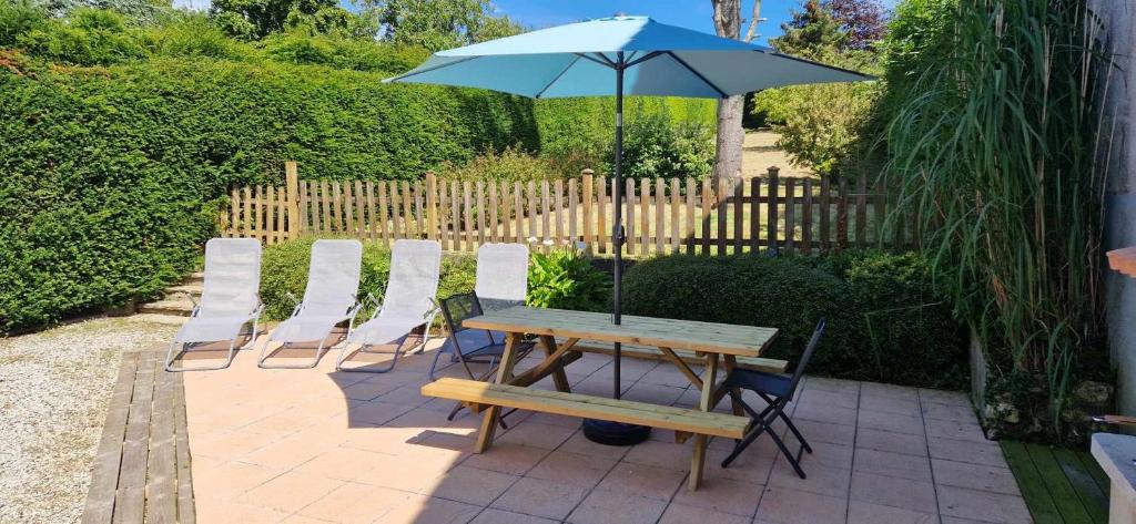une table et des chaises avec un parasol et un banc dans l'établissement BB escapade, à Saint-Léonard