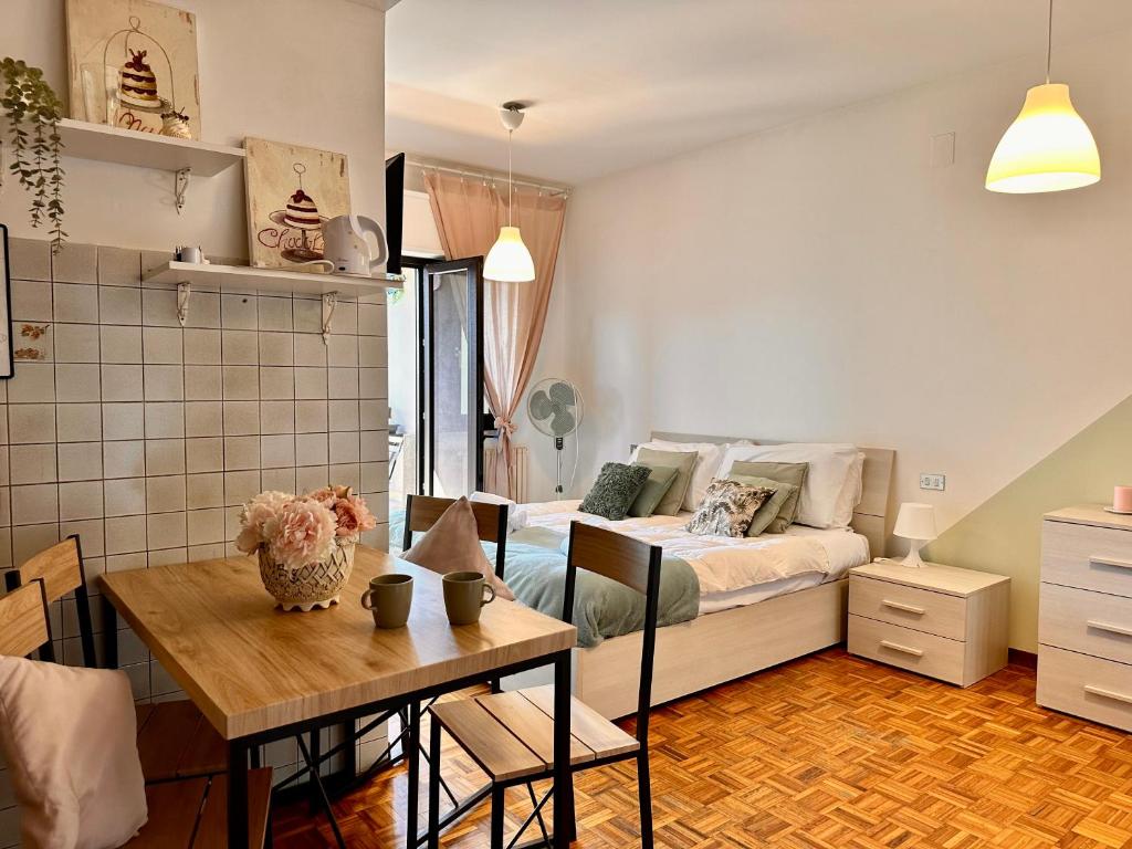 a bedroom with a bed and a table and a dining room at Spacious Studio Apartment with Terrace in Perugia