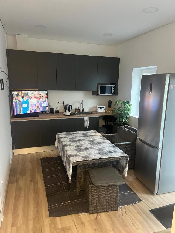 a kitchen with a table and a stainless steel refrigerator at Friend's House in Maia