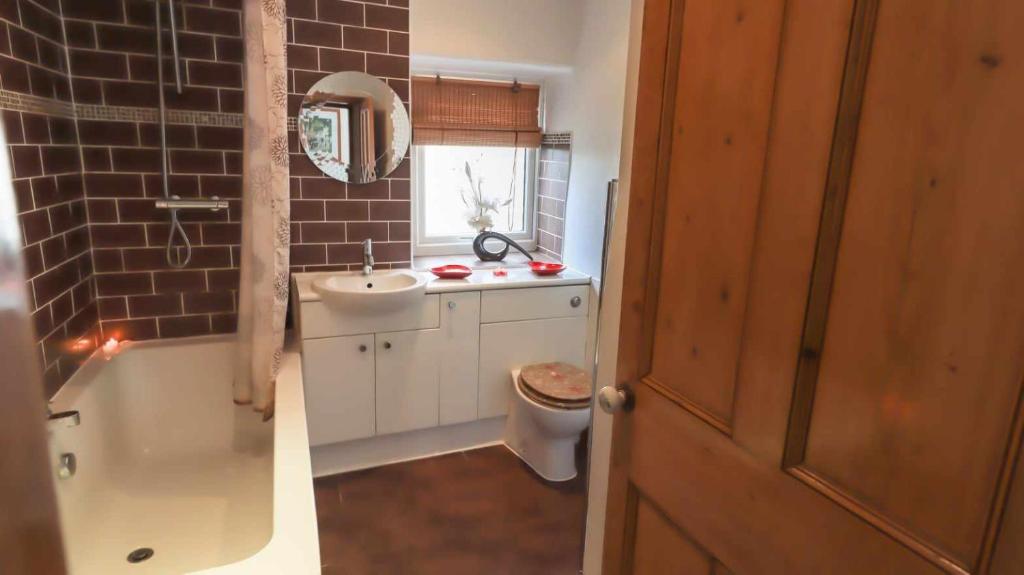 a bathroom with a sink and a tub and a toilet at Commerce Cottage Rooms in Ripley