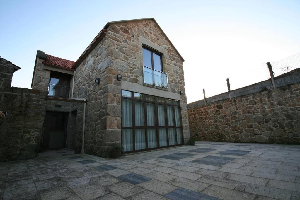 a large brick building with a large window on it at Casa en Fontecova in Cuntis
